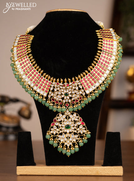 Antique necklace with jadau kundan stones and pearl & pumpkin beads hanging without earrings