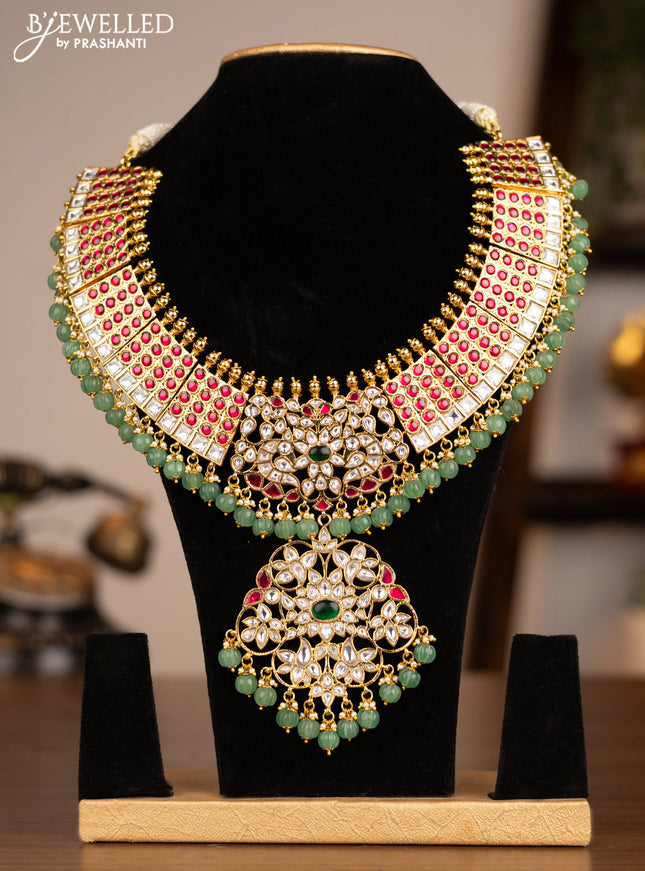 Antique necklace with jadau kundan stones and pearl & pumpkin beads hanging without earrings