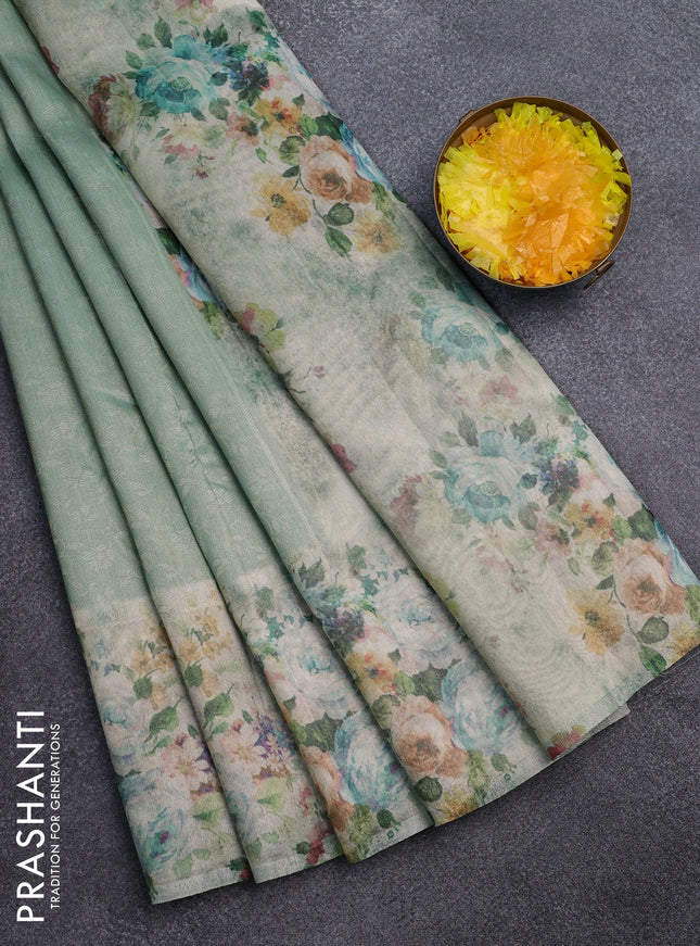 Tissue saree teal green shade with allover zari weaves and floral digital printed border