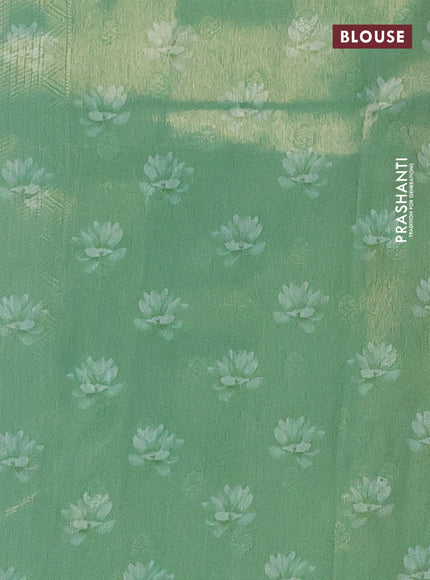 Tissue saree teal green shade with allover zari weaves and floral digital printed border
