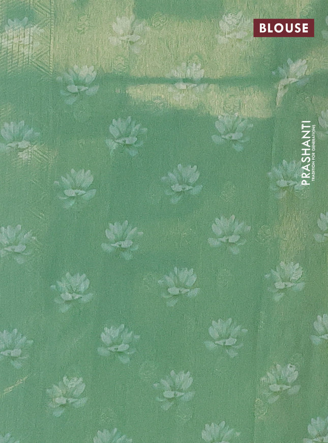 Tissue saree teal green shade with allover zari weaves and floral digital printed border