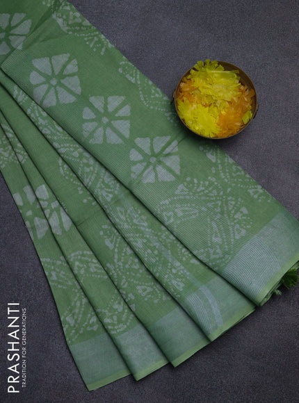 Pure linen saree teal green shade with allover batik prints and silver zari woven border