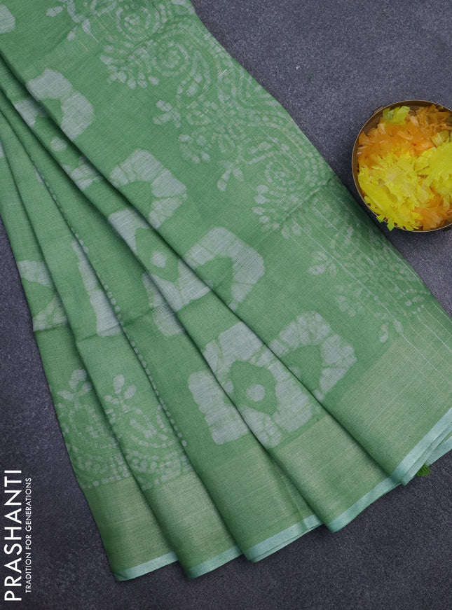 Pure linen saree light green with allover batik prints and zari woven border