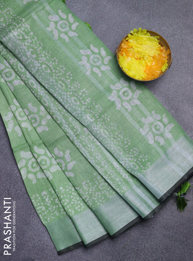 Pure linen saree green shade and black with allover batik prints and silver zari woven border