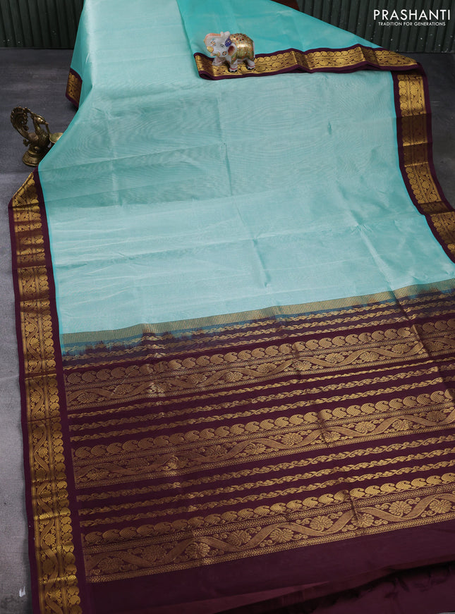 Silk cotton saree teal green and deep wine with plain body and zari woven korvai border