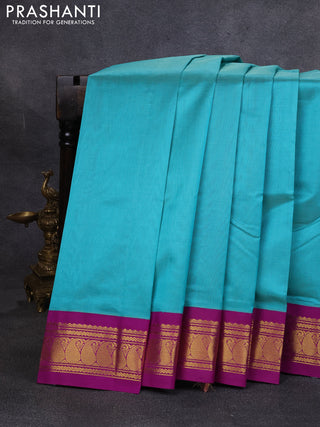 Silk cotton saree teal green and purple with plain body and paisley zari woven korvai border