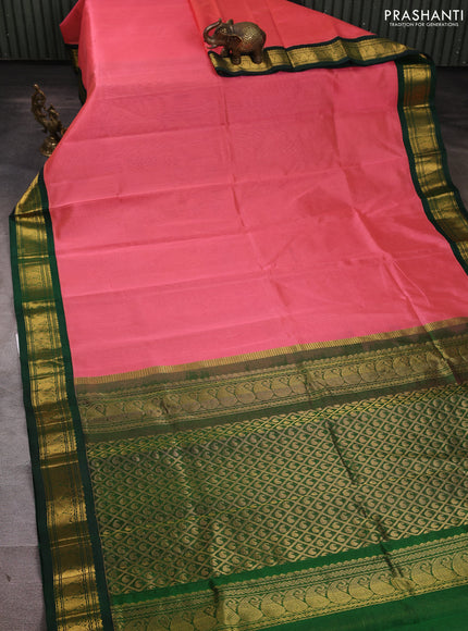 Silk cotton saree peach pink and bottle green with plain body and paisley zari woven korvai border