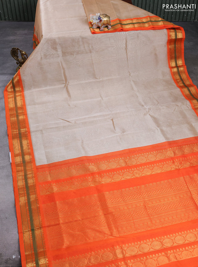 Silk cotton saree beige and orange with plain body and zari woven korvai border