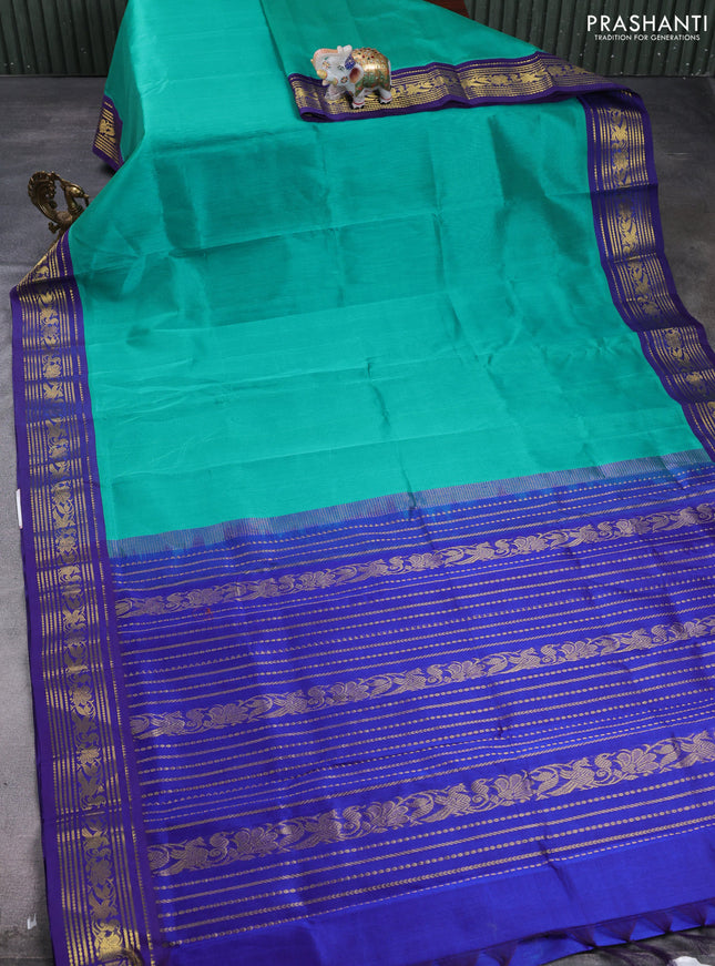 Silk cotton saree teal green and navy blue with plain body and zari woven korvai border