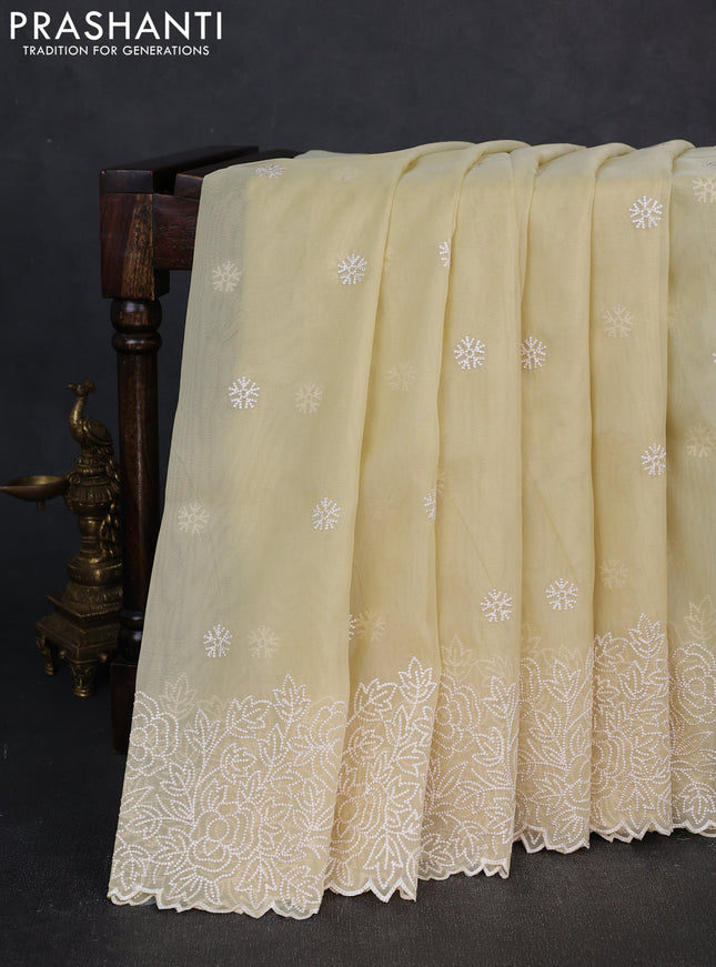 Organza saree pale yellow with embroidery buttas and floral embroidery border