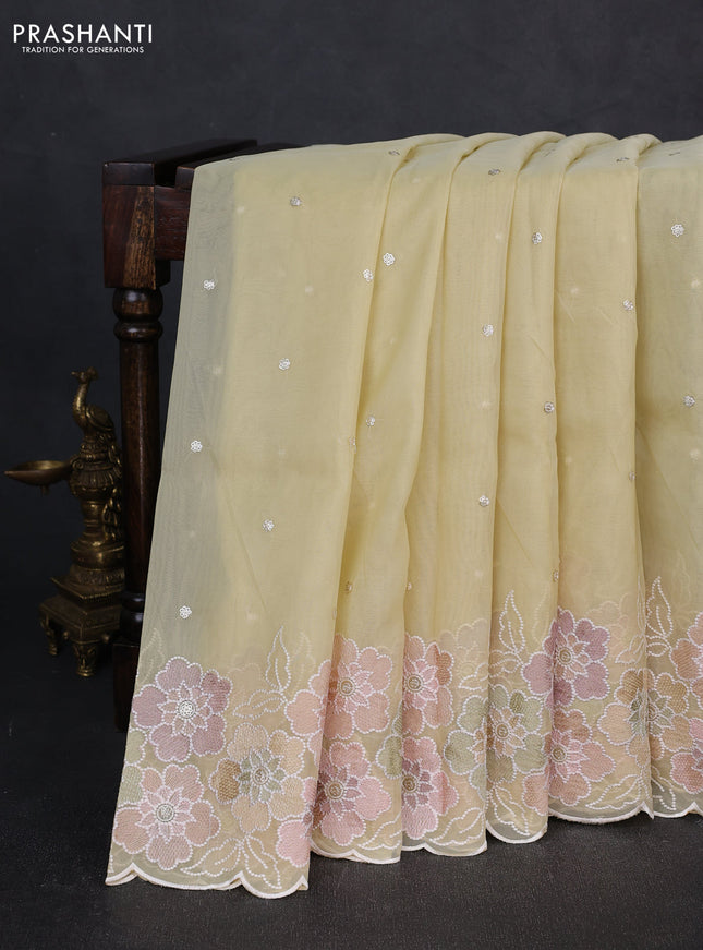 Organza saree pale yellow with sequin embroidery buttas and floral embroidery border