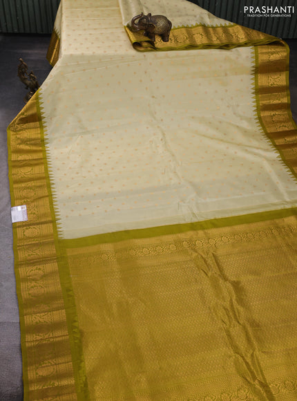 Pure gadwal silk saree cream and mehendi green with allover zari woven buttas and temple design zari woven border