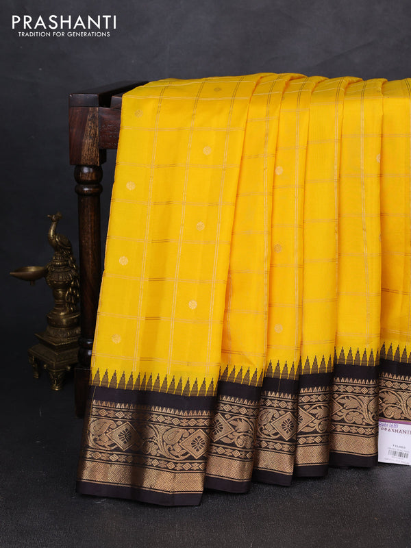 Pure gadwal silk saree yellow and coffee brown with allover zari checks & buttas and temple design zari woven border