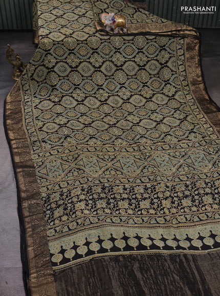 Dola silk saree black with allover ajrakh prints and zari woven border