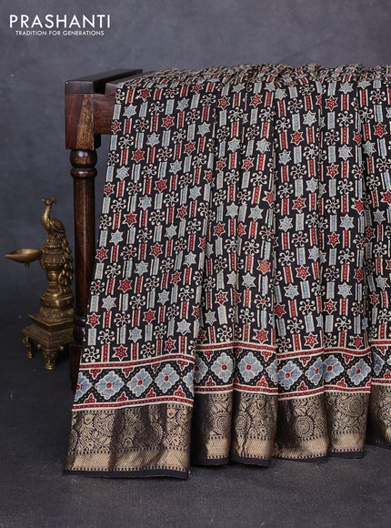 Dola silk saree black with allover ajrakh prints and zari woven border