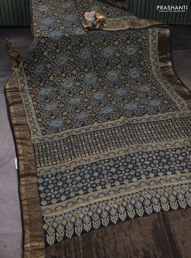 Dola silk saree black with allover ajrakh prints and zari woven border