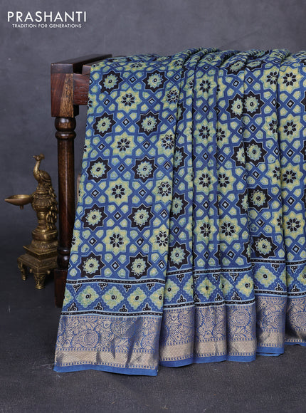 Dola silk saree blue shade with allover ajrakh prints and zari woven border