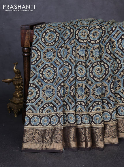 Dola silk saree blue shade with allover ajrakh prints and zari woven border