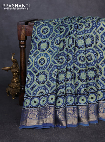 Dola silk saree blue shade with allover ajrakh prints and zari woven border
