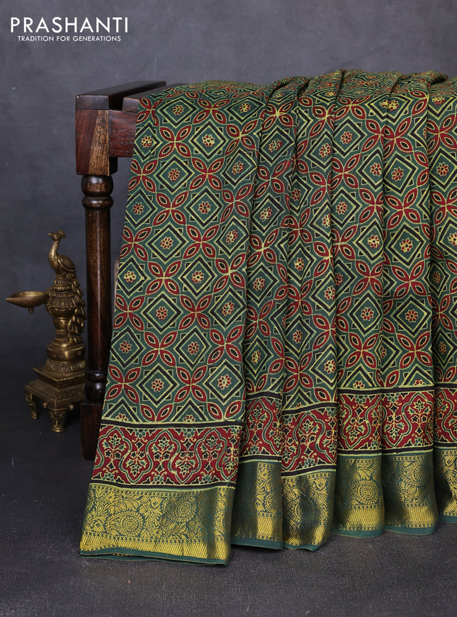Dola silk saree green shade with allover ajrakh prints and zari woven border