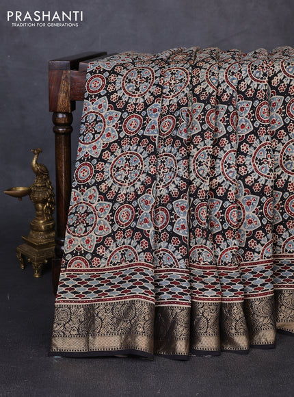 Dola silk saree black with allover ajrakh prints and zari woven border