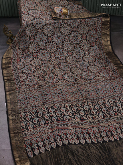 Dola silk saree black with allover ajrakh prints and zari woven border