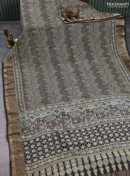 Dola silk saree black with allover ajrakh prints and zari woven border