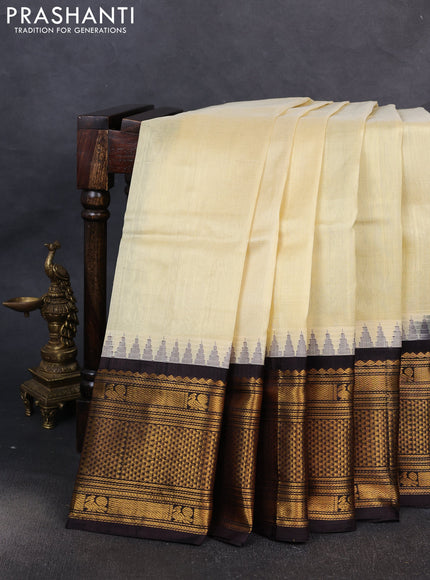 Kuppadam silk cotton saree cream and coffee brown with plain body and temple design long zari woven border