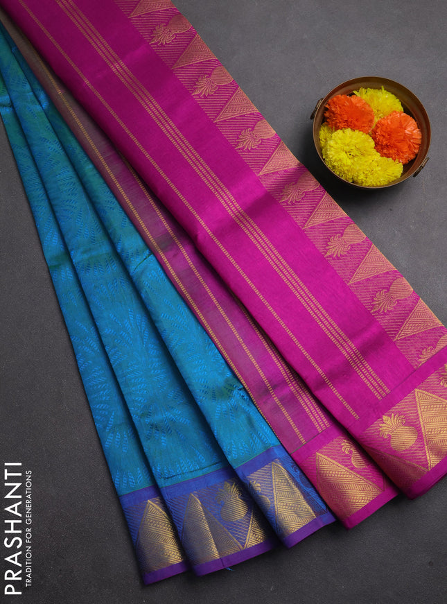Silk cotton saree dual shade of teal bluish green and purple with allover self emboss jacquard and zari woven border