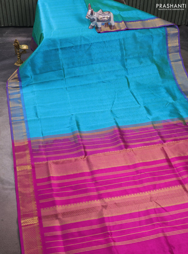 Silk cotton saree dual shade of teal bluish green and purple with allover self emboss jacquard and zari woven border