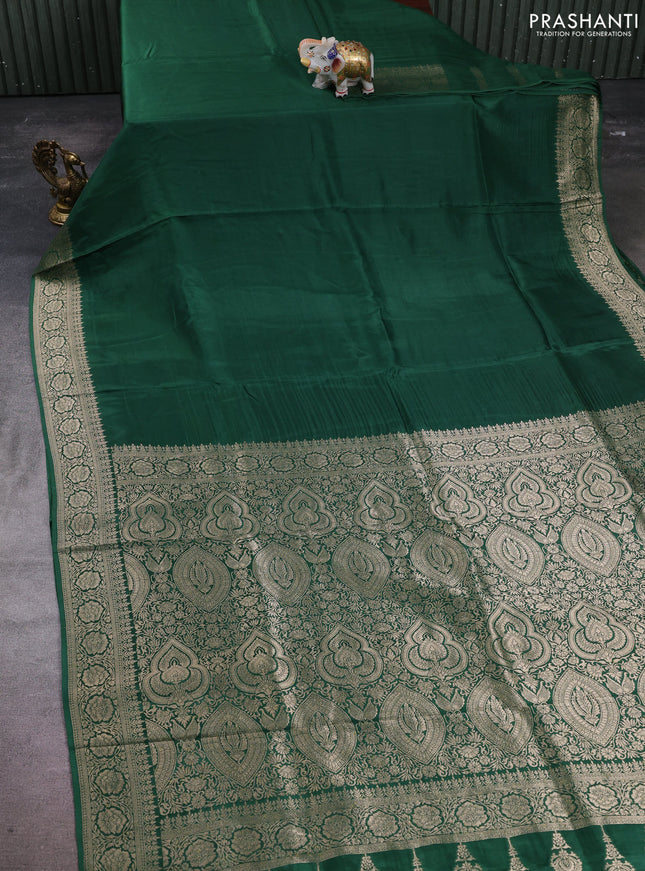 Dola silk saree bottle green with plain body and zari woven border
