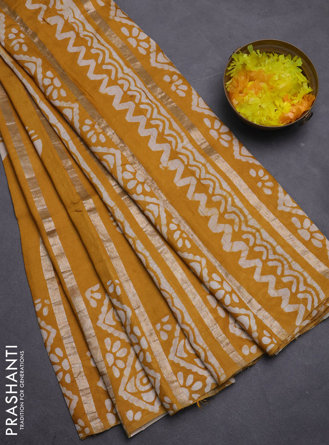 Semi chanderi saree mustard yellow with allover zari strips & batik butta prints in borderless style