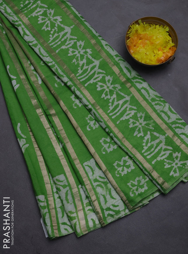 Semi chanderi saree parrot green with allover zari strips & batik butta prints in borderless style