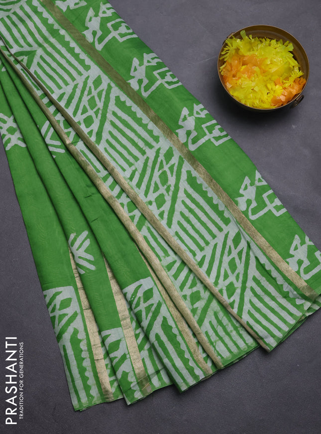 Semi chanderi saree parrot green with allover zari strips & batik butta prints in borderless style