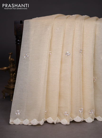 Crush tissue saree cream with sequin work buttas and beaded work border