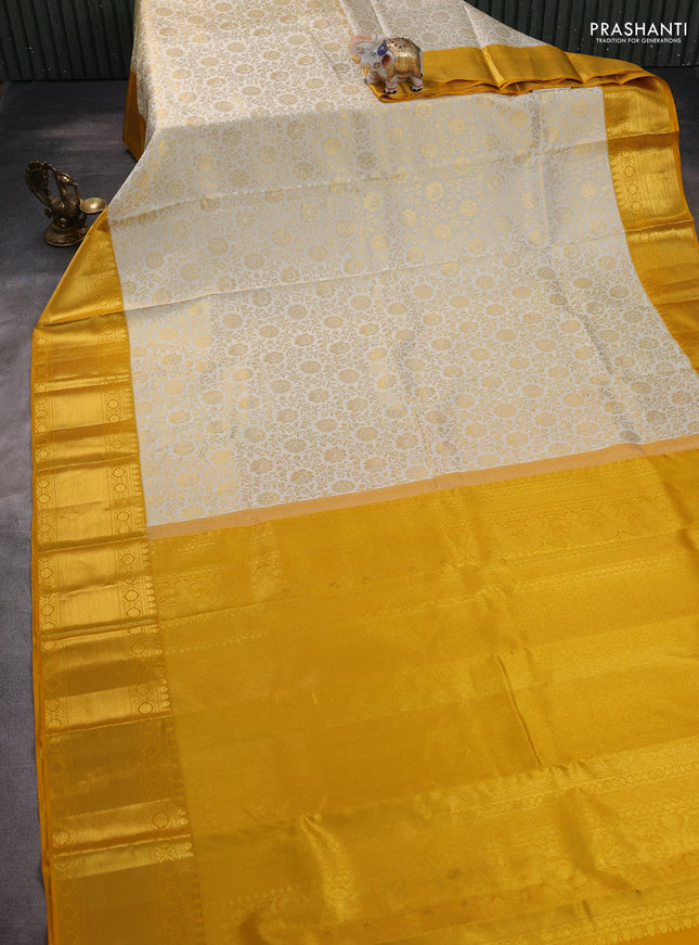 Pure kanchipuram silk saree off white and mustard yellow with allover zari woven brocade weaves and zari woven border