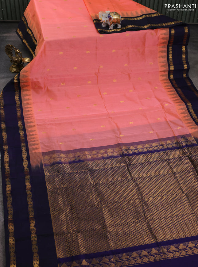 Silk cotton saree pale orange and navy blue with paisley zari woven buttas and temple design rettapet zari woven korvai border