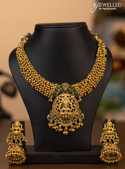 Antique necklace lakshmi pendant with green kemp stones and golden beads hanging