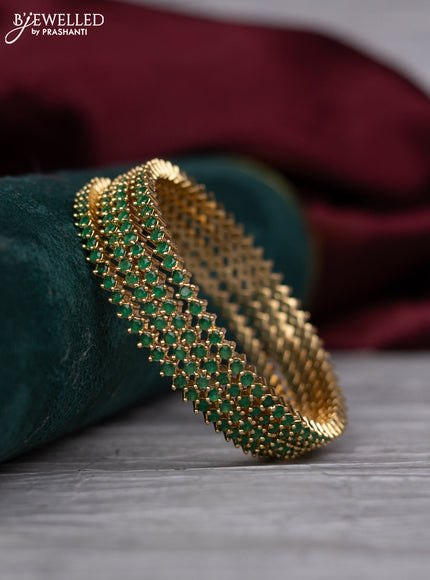 Zircon bangle with emerald stones in gold finish