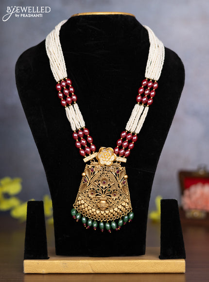 Pearl necklace floral design with kemp & cz stones and green beads hanging without earrings