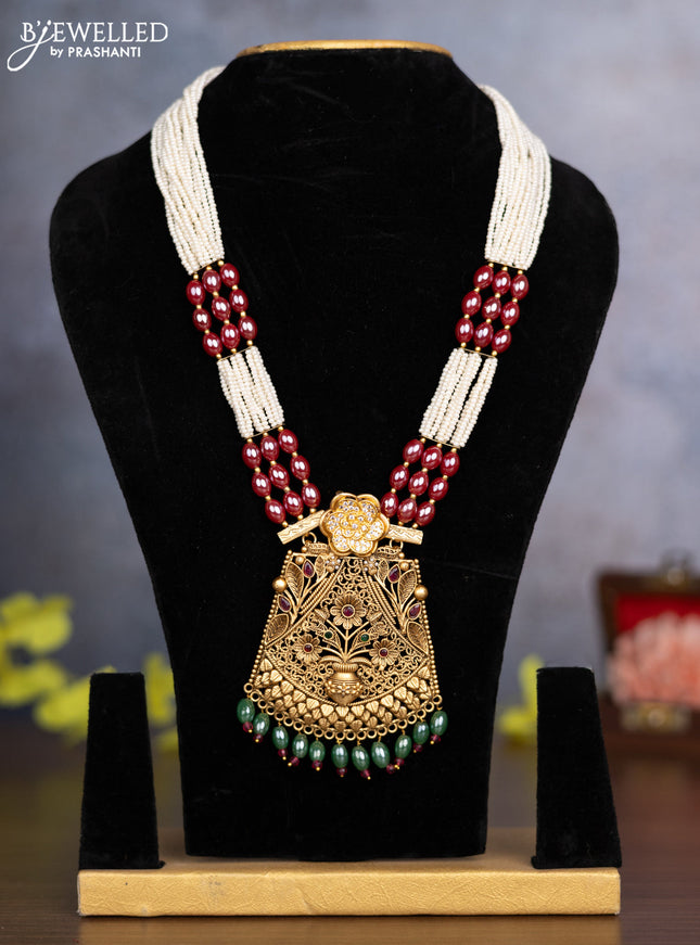 Pearl necklace floral design with kemp & cz stones and green beads hanging without earrings