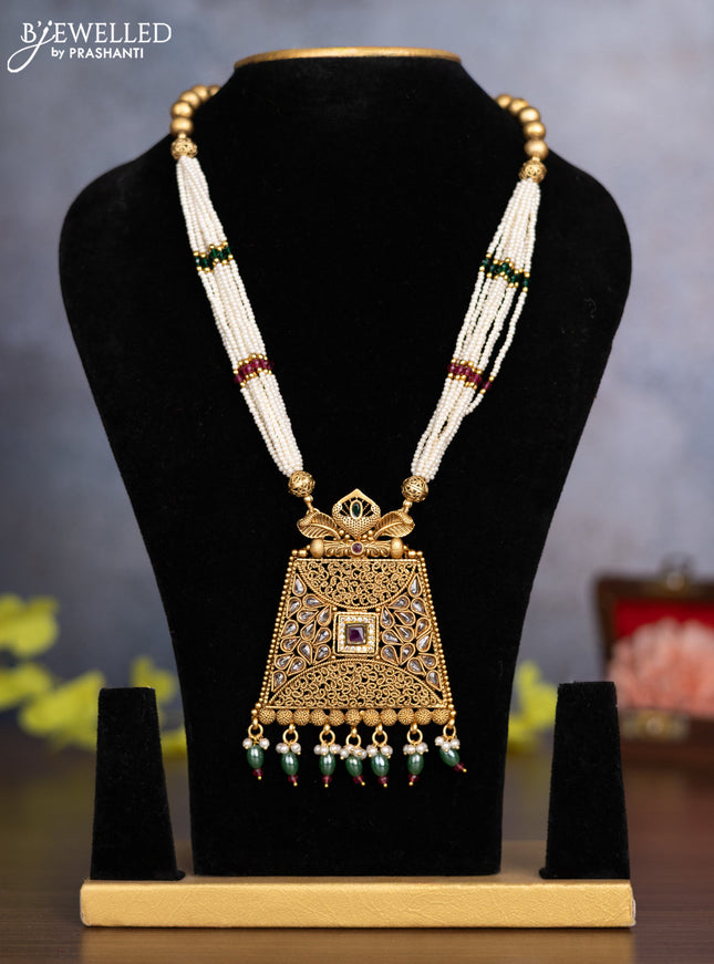 Pearl necklace with kemp & cz stones and pearl & green beads hanging without earrings