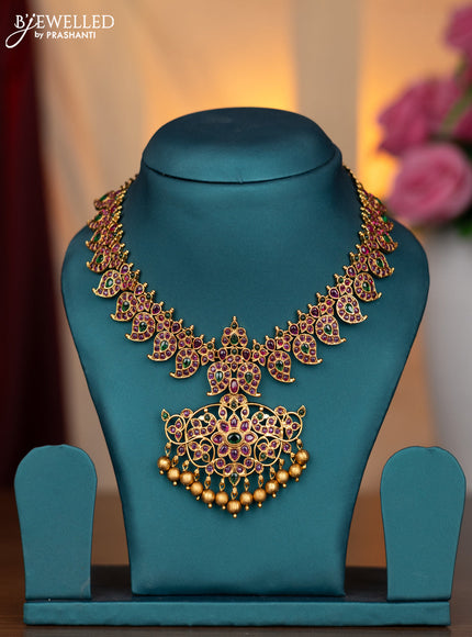 Antique necklace manga pattern with kemp stones and golden beads hanging without earring