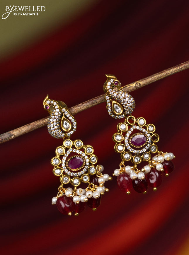 Earring with peacock design ruby & cz stones and pearl & pink beads hanging in victorian finish