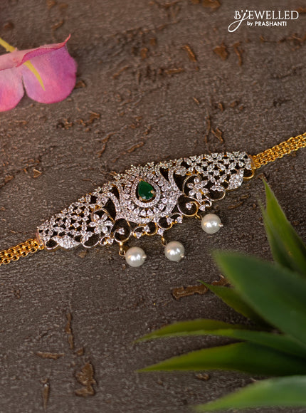 Zircon vanki with emerald & cz stones and pearl hangings in gold finish
