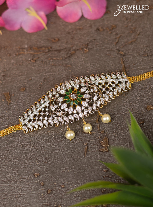 Zircon vanki with emerald & cz stones and pearl hangings in gold finish