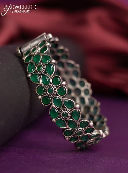 Oxidised floral design screw type bangle with emerald stones