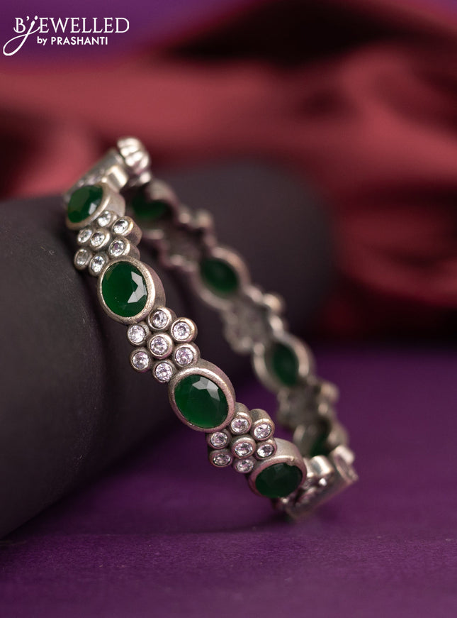 Oxidised floral design screw type bangle with emerald and cz stones