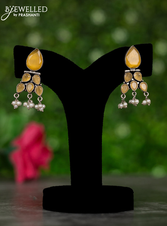 Oxidised hanging type earrings with yellow stones and pearl hangings