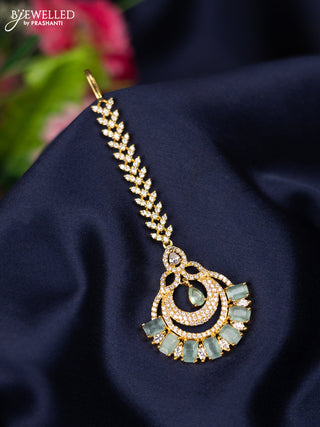 Zircon maang tikka with mint green and cz stones in gold finish
